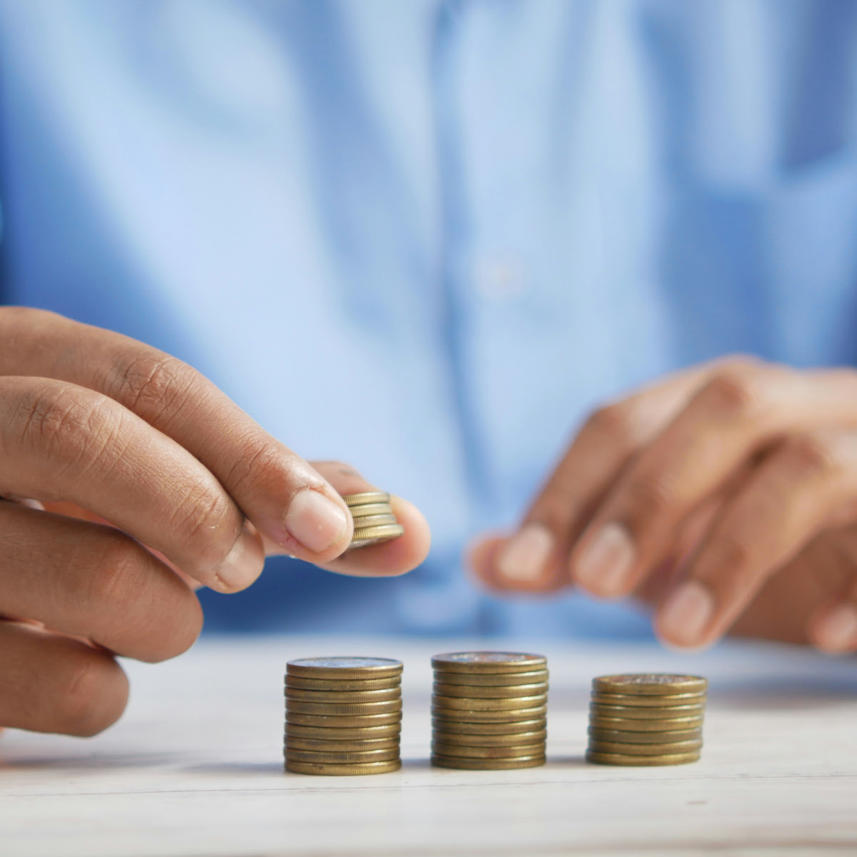 Poupança – Quanto Poupar Poupar dinheiro, mãos a fazer montinhos com moedas - Quanto Poupar